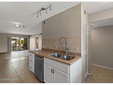 Bright kitchen featuring stainless steel appliances, double basin sink, and tile backsplash at 7430 E Chaparral Rd # A239, Scottsdale, AZ 85250