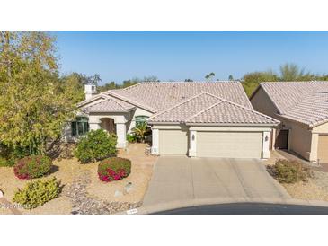 Charming home featuring a landscaped front yard, two-car garage, and a neutral-toned tiled roof at 1240 E Friess Dr, Phoenix, AZ 85022