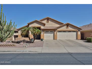 Inviting single-story home featuring a three-car garage and desert landscaping with a mature cactus and palm trees at 12814 W Windrose Dr, El Mirage, AZ 85335