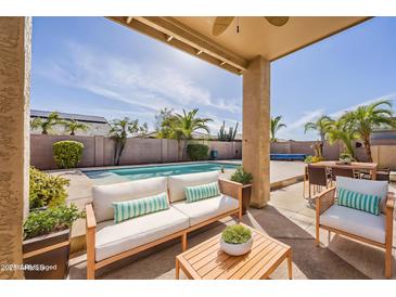 Inviting pool area with comfortable seating, palm trees, and ample space for outdoor relaxation and entertainment at 14837 W Crocus Dr, Surprise, AZ 85379