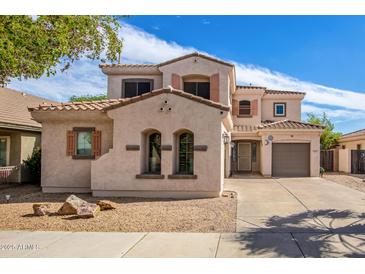 Two-story home featuring desert landscaping, warm earthy tones, and a tile roof at 17423 W Yavapai St, Goodyear, AZ 85338