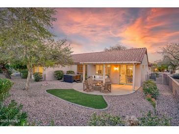 The backyard features a gravel landscape, with a covered patio, hot tub, and outdoor seating, and a turf grass accent at 17882 N Painted Spurge Ct, Surprise, AZ 85374