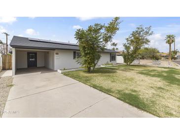 Charming single-story home with a well-maintained lawn and a covered parking area at 1908 N 47Th St, Phoenix, AZ 85008