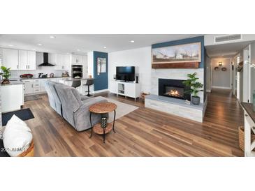 Open-concept living room boasts a fireplace, modern finishes and flows into the updated kitchen at 2065 E Alameda Dr, Tempe, AZ 85282