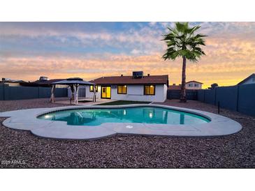 Inviting backyard featuring a sparkling pool, gazebo, and lush palm tree, perfect for outdoor relaxation and entertaining at 2110 W Pampa Ave, Mesa, AZ 85202