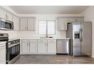 Charming kitchen featuring stainless steel appliances, gray cabinets, and ample counter space at 23276 W Cocopah St, Buckeye, AZ 85326