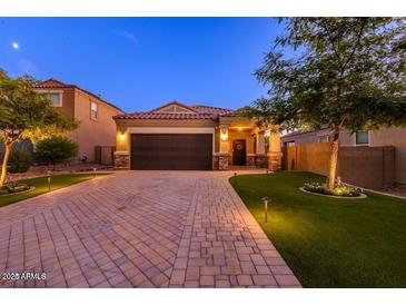 Beautiful single-Gathering home with a two-car garage, brick driveway, and manicured front yard landscaping at 29219 W Clarendon Ave, Buckeye, AZ 85396