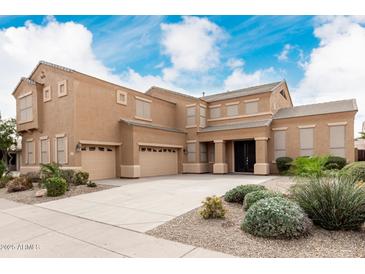 Expansive home featuring a large three car garage, desert landscaping, and covered front entryway at 3317 W Knudsen Dr, Phoenix, AZ 85027