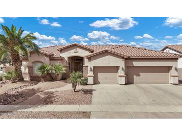 Charming single-story home featuring a tile roof, well-manicured landscaping, and a three-car garage at 4618 E Carriage Ct, Gilbert, AZ 85297