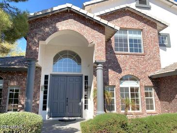 Inviting front entrance with a brick facade, arched doorway, and well-maintained landscaping at 6834 E Culver St, Mesa, AZ 85207