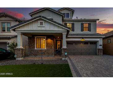 Beautiful two-story home with a brick and stone facade and a well-manicured front lawn at twilight at 717 E Deer Creek Rd, Phoenix, AZ 85048