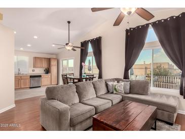 Bright living room featuring a large sectional sofa, wood floors, and access to the kitchen and outdoor patio at 930 W Hudson Way, Gilbert, AZ 85233