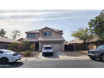 Charming two-story home with a well-maintained front yard and a two car garage and a newer vehicle at 9335 W Kingman St, Tolleson, AZ 85353