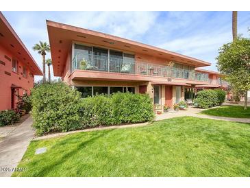 Charming two-story building with a manicured lawn and beautiful landscaping under a blue sky at 120 E Coronado Rd # 9, Phoenix, AZ 85004