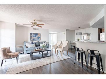 Bright living room with hardwood floors, modern furniture, and a view into the kitchen at 16402 N 31St St # 115, Phoenix, AZ 85032