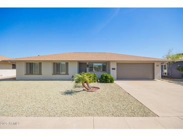 Charming single-story home featuring a gravel yard, desert landscaping, and attached two-car garage at 16413 N Orchard Hills Dr, Sun City, AZ 85351