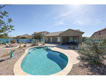 Backyard featuring a swimming pool, patio and desert landscaping at 18178 W Desert View Ln, Goodyear, AZ 85338