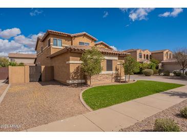 Charming two-story home with landscaped yard and inviting curb appeal under a sunny blue sky at 18436 E Celtic Manor Dr, Queen Creek, AZ 85142