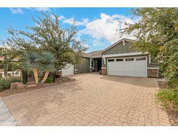 Charming single-story home featuring a three-car garage and a well-manicured desert landscaped front yard at 3123 E Cat Balue Dr, Phoenix, AZ 85050