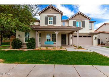 Charming two-story home with a welcoming front porch and manicured lawn at 3632 E Comstock Dr, Gilbert, AZ 85296