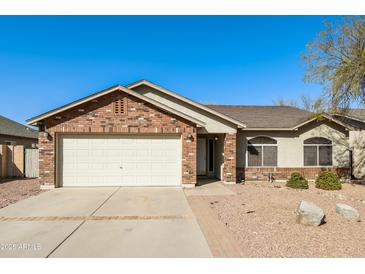 Charming single-story home featuring a brick facade and two-car garage, complemented by a well-maintained landscape at 40144 N Lerwick Dr, San Tan Valley, AZ 85140