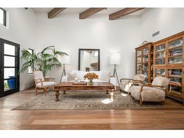 Open living room features exposed wood beam ceilings, wood floors, and a decorative area rug at 5101 N Casa Blanca Dr # 217, Paradise Valley, AZ 85253