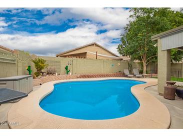 Sparkling pool in a private backyard with desert landscaping and lounge chairs, ideal for relaxation at 9212 W Salter Dr, Peoria, AZ 85382