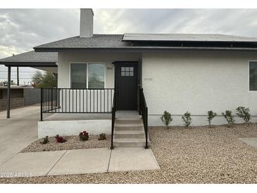 Charming front door with modern railings and beautiful landscaping enhance the entrance of this home at 9810 N 2Nd Way, Phoenix, AZ 85020