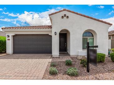 Charming home featuring a tile roof, arched entry, and low maintenance desert landscaping at 9823 E Red Giant Dr, Mesa, AZ 85212