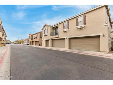 Street view of townhomes with two-car garages and neutral colored stucco at 1265 S Aaron -- # 355, Mesa, AZ 85209