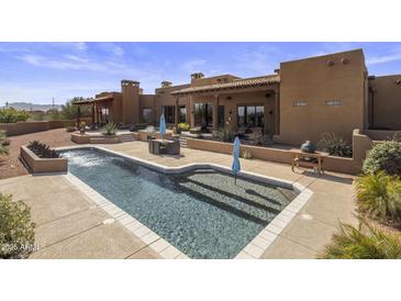 Inviting outdoor pool and patio area perfect for relaxing and entertaining with desert landscaping and blue skies at 31912 N 141St St, Scottsdale, AZ 85262