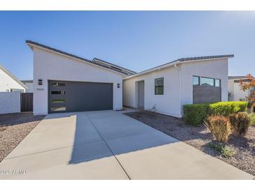 Contemporary home featuring desert landscaping, a gray garage door, and a light-colored facade at 35231 N Danburite Ct, San Tan Valley, AZ 85144