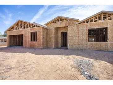 New home construction featuring wood framing, and a spacious two-car garage under a blue, partly cloudy sky at 4115 E Windsor Ave, Phoenix, AZ 85008