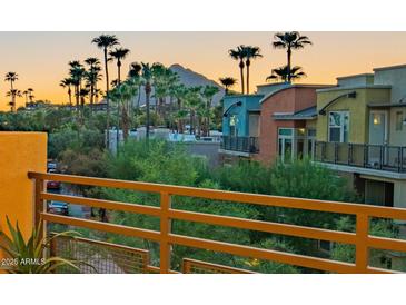 A colorful exterior view with palm trees in the background and the desert mountains during a sunset at 4803 N Woodmere Fairway -- # 3009, Scottsdale, AZ 85251