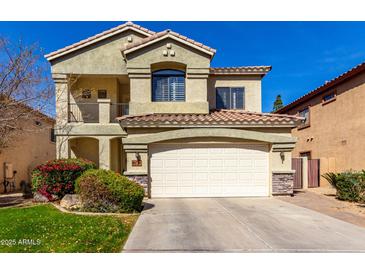 Charming two-story home with a well-manicured front lawn and a two-car garage and tiled roof at 5234 E Carol Ave, Mesa, AZ 85206
