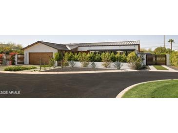 Beautiful exterior view with manicured landscaping, a well-maintained lawn, and a gated driveway at 5812 N 44Th Pl, Phoenix, AZ 85018