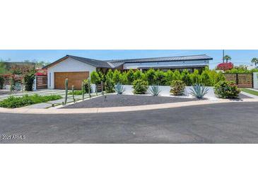 Modern home boasts elegant landscaping with cacti, shrubs, and a well-maintained black gravel area at 5812 N 44Th Pl, Phoenix, AZ 85018