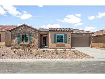 Charming single-story home featuring stone accents, desert landscaping, and a tile roof at 7870 W Mockingbird Way, Florence, AZ 85132