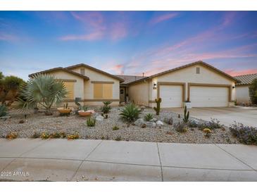 Charming single-story home featuring desert landscaping, a two-car garage, and a neatly maintained front yard at 10505 W Wilshire Dr, Avondale, AZ 85392