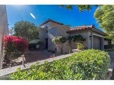 Charming home featuring desert landscaping, a brick walkway, and a cozy, enclosed two-car garage at 10557 E Fanfol Ln, Scottsdale, AZ 85258