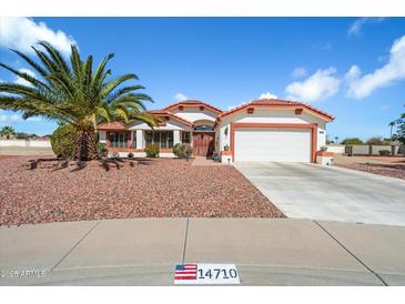 Charming single story home featuring a 2-car garage, well manicured landscaping, and a red tile roof at 14710 W Yosemite Dr, Sun City West, AZ 85375