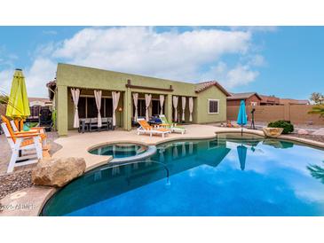 Inviting pool area with lounge chairs and a covered patio, perfect for outdoor relaxation and entertaining at 15620 W Meadowbrook W Ave, Goodyear, AZ 85395