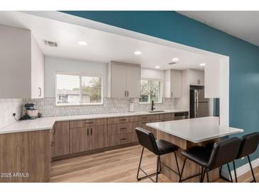 Modern kitchen featuring a breakfast bar, updated cabinets, countertops and stainless steel appliances at 1824 W State Ave, Phoenix, AZ 85021