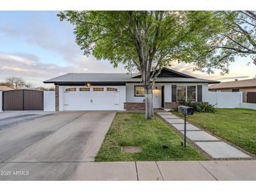 Charming single-story home with well-manicured lawn and a spacious two-car garage and stylish finishes at 1849 E 2Nd Pl, Mesa, AZ 85203