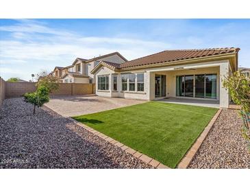Backyard featuring a covered patio, a low-maintenance artificial lawn, and gravel landscaping at 1855 E Crescent Way, Chandler, AZ 85249