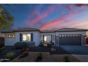 Charming single-story home featuring desert landscaping, a two-car garage, and a covered front entrance at dusk at 19861 S 191St St, Queen Creek, AZ 85142