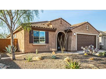 A charming home showcasing desert landscaping, shuttered windows, and a two-car garage at 21362 N 260Th Ln, Buckeye, AZ 85396