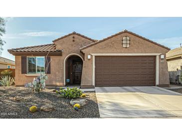 Charming home featuring desert landscaping, a two-car garage, and a cozy, covered entryway at 21362 N 260Th Ln, Buckeye, AZ 85396