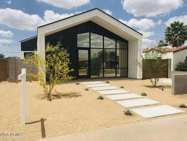 Modern home boasts a striking black and white exterior with large picture window and desert landscaping at 2336 N 12Th St, Phoenix, AZ 85006