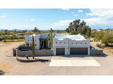 Stunning white desert home featuring a two-car garage and a unique architectural design with desert landscaping at 28404 N 67Th St, Cave Creek, AZ 85331